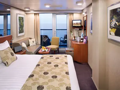 Gemütlich eingerichtete Balkonkabine an Bord der Eurodam mit Doppelbett, Sofa, Sessel und Balkon zum Meer.