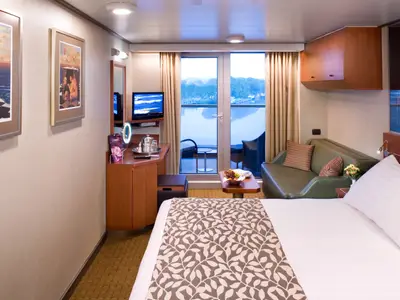 Einblick in eine stilvoll eingerichtete Balkonkabine an Bord der Eurodam mit Doppelbett, Sofa und Balkonöffnung.