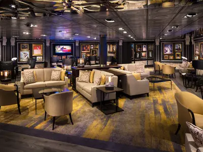 Die gemütlich gestaltete Gallery Bar an Bord der Eurodam mit stilvollen Sofas, Sesseln und zahlreichen Gemälden an den Wänden.