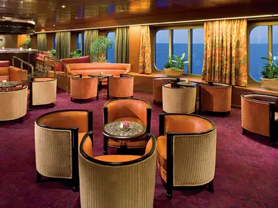 Die elegant gestaltete Explorer's Lounge an Bord der Eurodam bietet gemütliche Sessel und einen weiten Blick auf das offene Meer.