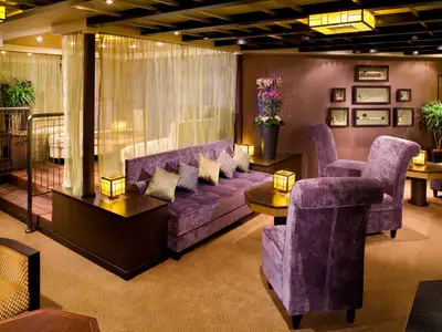 Die elegante Silk Den Lounge an Bord der Eurodam mit lila Samtmöbeln, warmen Laternen und asiatisch inspiriertem Dekor.