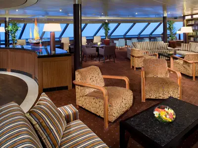 Die elegant eingerichtete Crow's Nest Lounge an Bord der Eurodam bietet gemütliche Sessel und eine große Fensterfront mit weitem Meerblick.