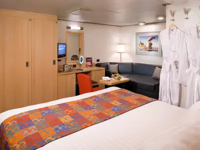 Ein Blick in eine komfortable Innenkabine an Bord der Eurodam mit Bett, Sofa, Schreibtisch und Bademänteln.