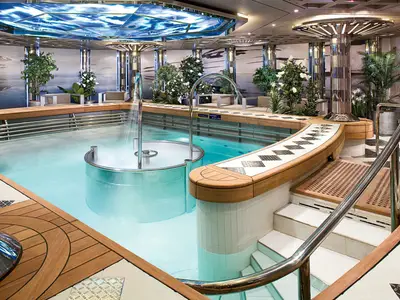 Ein beheizter Hydrotherapie-Pool mit Düsen und Holzverkleidung im eleganten Wellnessbereich an Bord der Eurodam.