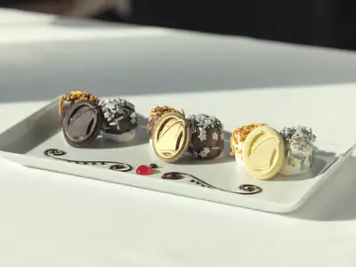 Köstliche, kunstvoll dekorierte Schoko-Marshmallows auf einer weißen Platte an Bord der Eurodam.