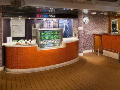 Der Counter von 'New York Pizza' an Bord der Eurodam mit einer Vitrine voller Salate und Desserts vor einer Mosaikwand.