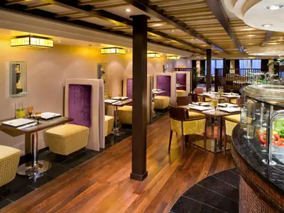 Blick in das asiatische Restaurant Tamarind an Bord der Eurodam mit eleganten lila und gelben Sitzbereichen.