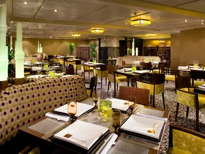 Blick in das asiatische Restaurant Tamarind an Bord der Eurodam mit elegant gedeckten Tischen und warmem Licht.