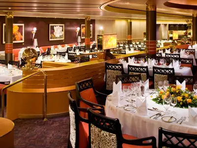 Festlich gedeckte Tische im eleganten Rembrandt-Restaurant an Bord der Eurodam mit feinen Gläsern und Blumengestecken.