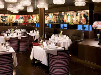 Das elegant gestaltete Pinnacle Grill Restaurant an Bord der Eurodam mit fein eingedeckten Tischen, stimmungsvoller Beleuchtung und Kunstwerken.