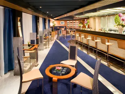Die modern gestaltete Pinnacle Grill Bar an Bord der Eurodam mit einer langen Theke und gemütlichen Sitzecken.