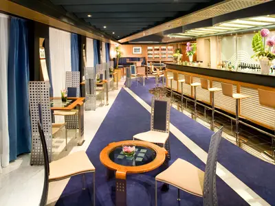 Die elegante Pinnacle Bar an Bord der Eurodam mit einer geschwungenen Theke, Barhockern und gemütlichen Sitzecken.
