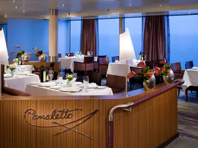 Eingedeckte Tische im stilvollen Canaletto Restaurant an Bord der Eurodam mit Panoramablick auf das blaue Meer.
