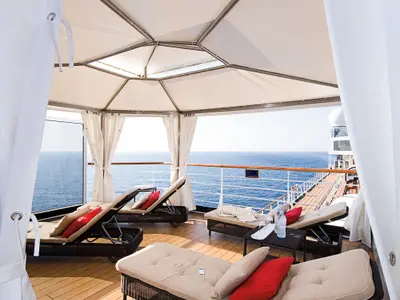 Einblick in eine private Cabana im exklusiven Außenbereich 'The Retreat' an Bord der Eurodam mit Blick auf den Ozean.