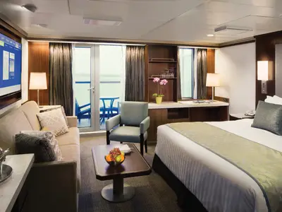 Blick in eine geräumige Signature Suite an Bord der Eurodam mit Doppelbett, Sitzecke und Balkon.