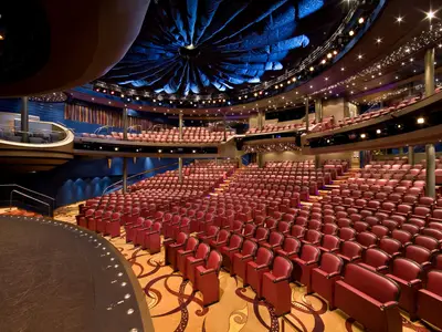 Blick in das große Theater 'The Mainstage' an Bord der Eurodam mit roten Zuschauerrängen und einer blauen Deckenkonstruktion.