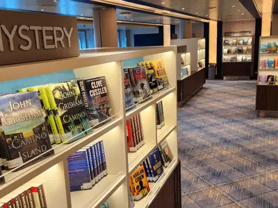 Blick auf gut gefüllte Bücherregale im Mystery-Bereich der Bibliothek an Bord der Koningsdam.