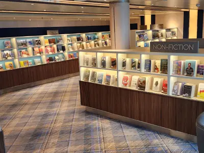 Die stilvoll eingerichtete Bibliothek an Bord der Koningsdam mit gut gefüllten Bücherregalen.