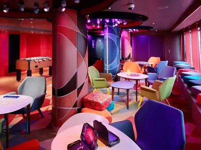 Blick in den bunt gestalteten Jugendraum 'The Loft' an Bord der Koningsdam mit Tischkicker, bunten Sesseln und Spielen.