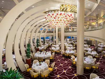 Das elegante, zweistöckige Hauptrestaurant an Bord der Koningsdam besticht durch geschwungene weiße Bögen und eine beeindruckende Lichtinstallation.