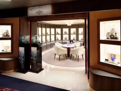 Blick in das luxuriöse Merabella Schmuckgeschäft an Bord der Koningsdam mit Vitrinen und edler Sitzgruppe.