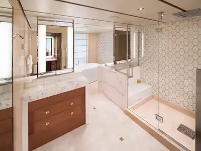 Das elegante Badezimmer einer Suite an Bord der Koningsdam verfügt über eine gläserne Dusche, Badewanne und Marmor-Waschtisch.