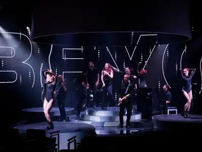 Künstler und Tänzer performen auf der modernen kreisförmigen World Stage Bühne an Bord der Koningsdam.