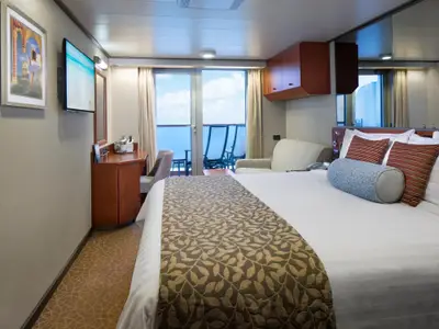 Blick durch eine gemütliche Balkonkabine mit Doppelbett an Bord der Nieuw Amsterdam auf das blaue Meer.