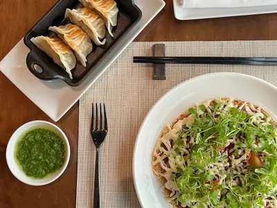 Asiatisches Essen wie Gyoza und Fladenbrot mit Kräutern an Bord der Nieuw Amsterdam aus der Vogelperspektive.