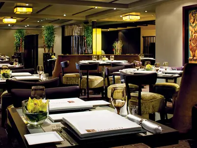 Eingedeckte Tische und asiatisches Dekor im eleganten Tamarind Restaurant an Bord der Nieuw Amsterdam.