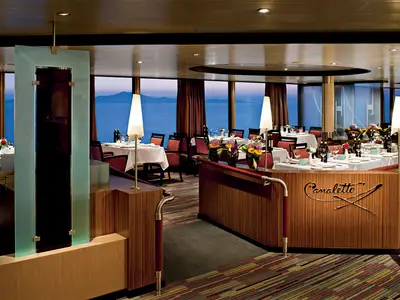 Das elegant gedeckte Restaurant Canaletto an Bord der Nieuw Amsterdam bietet einen traumhaften Ausblick auf das ruhige Meer zur Abendstimmung.