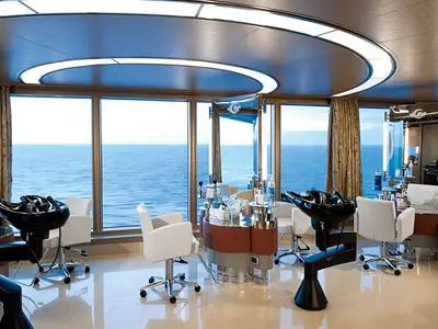 Ein heller Friseursalon an Bord der Nieuw Amsterdam mit modernen Styling-Plätzen und weitem Blick auf das blaue Meer.