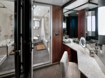 Blick in das elegante Badezimmer und den Frisiertisch-Bereich einer Neptune Spa Suite an Bord der Nieuw Amsterdam.