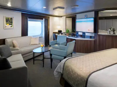 Blick in die großzügige Neptune Spa Suite an Bord der Nieuw Amsterdam mit bequemer Sitzecke und Meerblick.