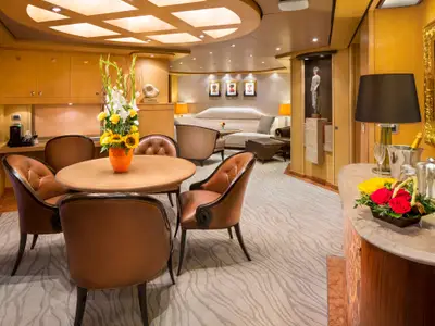 Eleganter Wohn- und Essbereich in der Pinnacle Suite an Bord der Nieuw Amsterdam mit runder Sitzgruppe und stilvoller Dekoration.