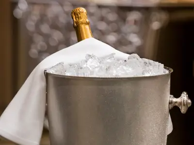 Nahaufnahme eines Champagnerkübels mit Eis und einer Flasche Champagner in einer Suite an Bord der Nieuw Amsterdam.