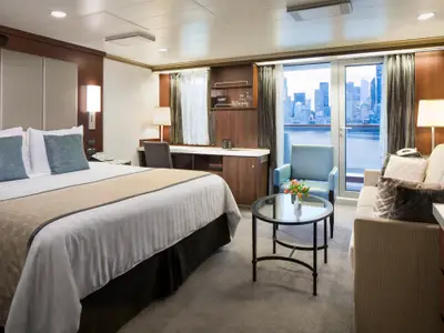 Die stilvolle Signature Suite an Bord der Nieuw Amsterdam bietet viel Platz, eine Sitzecke und einen Balkon vor einer Skyline.