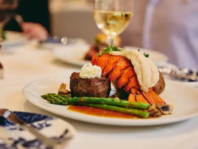 Nahaufnahme eines edlen Tellers mit Steak, Hummer und Spargel an Bord der Nieuw Statendam.
