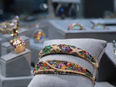 Nahaufnahme von farbenfrohen, edelsteinbesetzten Goldarmbändern im Shop an Bord der Nieuw Statendam.