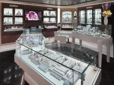 Ein elegantes Juweliergeschäft an Bord der Nieuw Statendam mit beleuchteten Glasvitrinen voller Schmuck und Ringe.