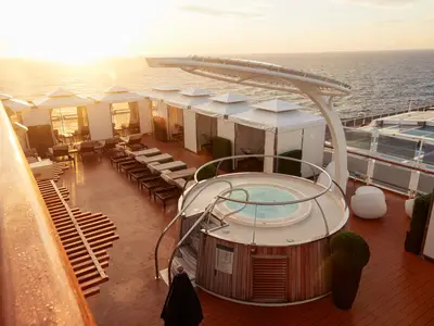 Whirlpool und private Cabanas im exklusiven Retreat-Bereich an Bord der Nieuw Statendam bei Sonnenuntergang.