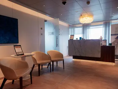 Wartebereich des Spas an Bord der Nieuw Statendam mit eleganten Sesseln und Marmor-Empfangstresen.