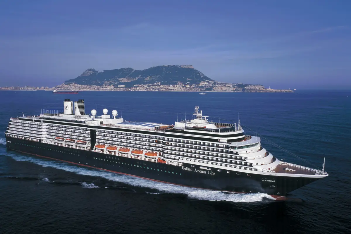Außenansicht des Kreuzfahrtschiffs Noordam auf dem blauen Meer mit dem markanten Felsen von Gibraltar im Hintergrund.