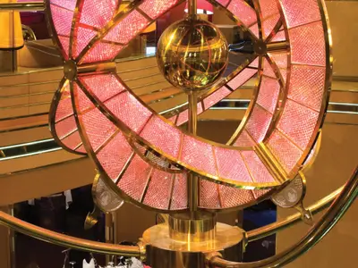 Nahaufnahme der eleganten, rot erleuchteten Kristall- und Goldskulptur im Atrium an Bord der Noordam.