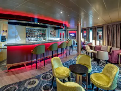 Stilvolle Bar-Lounge Billboard Onboard an Bord der Noordam mit einer rot beleuchteten Theke, eleganten Sesseln und gemütlichen Sitzecken.