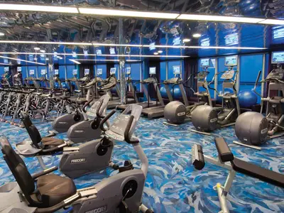 Das voll ausgestattete Fitnesscenter an Bord der Noordam mit modernen Trainingsgeräten, Laufbändern und einer spiegelnden Decke.