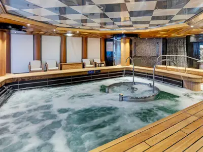 Der sprudelnde Hydrotherapiepool an Bord der Noordam, umgeben von elegantem Holzdeck und bequemen Liegen im Spa-Bereich.