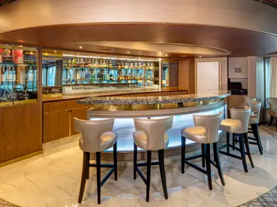 Die modern beleuchtete Pinnacle Bar an Bord der Noordam mit stilvollen Barhockern und einer edlen Getränkeauswahl.