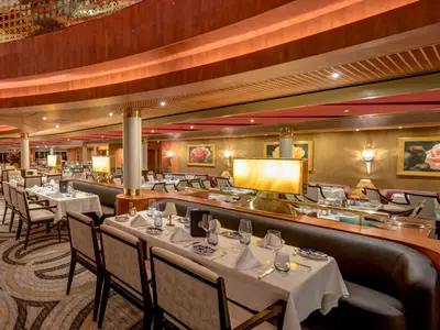 Einladender Blick in das edel gestaltete Hauptrestaurant an Bord der Noordam mit festlich gedeckten Tischen und warmem Licht.