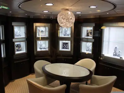 Blick in das elegante Merabella-Schmuckgeschäft an Bord der Noordam mit edlen Vitrinen, hellem runden Tisch und Ledersesseln.